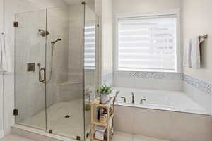 Bathroom featuring a garden tub, a stall shower, and tile patterned floors