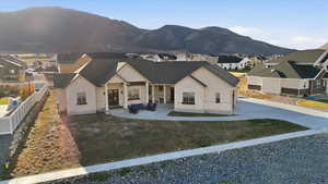 View of front of house with a mountain view, covered porch, board and batten siding, a residential view, and stone siding
