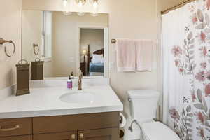 Ensuite bathroom with a shower with curtain and vanity