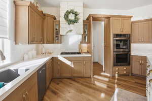 Kitchen featuring stainless steel appliances, tasteful backsplash, custom exhaust hood, light wood-type flooring, and glass insert cabinets
