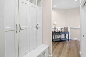 Mudroom with light wood finished floors and recessed lighting