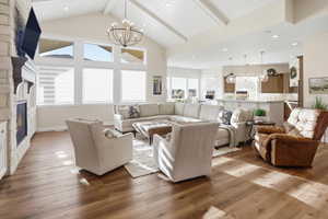 Living area featuring a fireplace, a chandelier, hardwood / wood-style floors, recessed lighting, and beamed ceiling