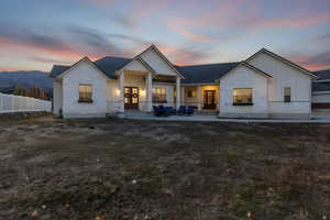 Rear view of house featuring stone siding, board and batten siding, a porch, and french doors