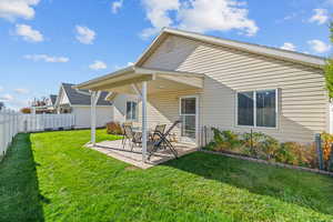 Rear view of house featuring a patio area and a fenced backyard