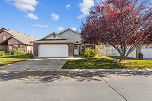 View of front of house featuring driveway, brick siding, and a garage