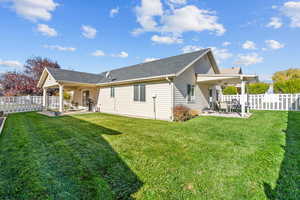 Back of house featuring a fenced backyard, a patio, and a shingled roof