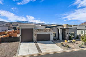 View of front of home featuring a mountain view, stucco siding, and stone siding