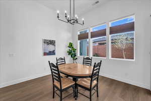 Dining space featuring dark wood-style floors and a chandelier