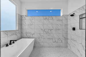 Bathroom with a freestanding bath, a tile shower, and tile walls