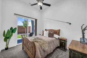 Bedroom with access to outside, dark carpet, and a ceiling fan