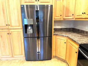 Kitchen featuring stainless steel fridge 4 door customizable doors with ice dispenser, black electric range, a