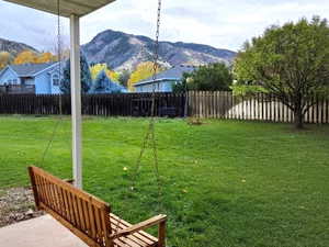 Fenced backyard featuring a patio area and a mountain view
