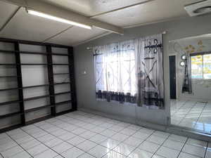 Living room with light tile-patterned floors and a textured ceiling