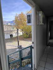 Doorway featuring tile patterned floors, a mountain view, and a wall unit AC