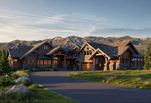 Craftsman-style house featuring stone siding, a mountain view, driveway, and a garage