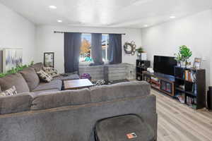 Living area with recessed lighting, wood finished floors, and a textured ceiling