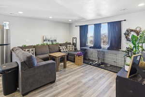 Living area with light wood-style floors and recessed lighting