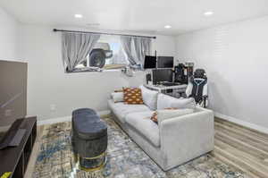 Living room featuring recessed lighting, wood finished floors, and a desk