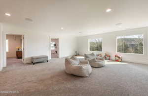Living area with carpet floors, healthy amount of natural light, and recessed lighting