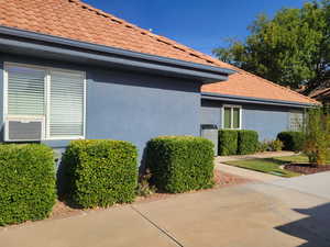 View of property exterior featuring stucco siding and a tiled roof