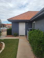 Doorway to property with stucco siding and a tiled roof