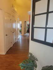 Corridor featuring dark wood finished floors and a towering ceiling