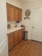 Kitchen with dark wood finished floors, light countertops, and brown cabinets