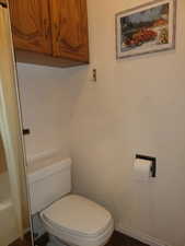 Bathroom with toilet and dark wood-style flooring