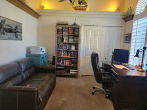 Office area with ceiling fan and light colored carpet
