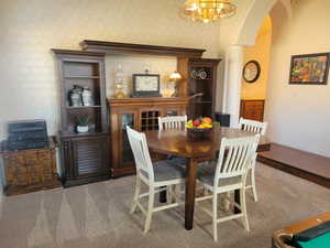 Dining space with arched walkways and a chandelier