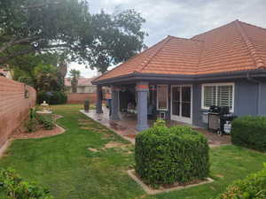 Rear view of house featuring a tiled roof, a patio, and stucco siding