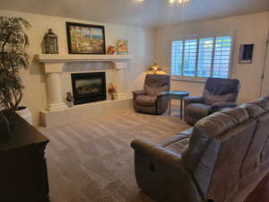 Carpeted living room with a tile fireplace and baseboards