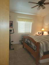 Bedroom with carpet floors, multiple windows, ceiling fan, and a textured ceiling
