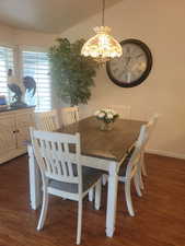 Dining area featuring dark wood-style floors and a chandelier