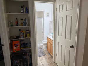 Full bath with a stall shower, light tile patterned flooring, and vanity