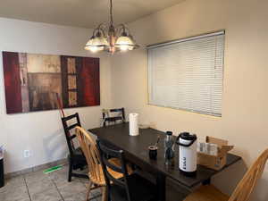 Dining room with light tile patterned floors and a chandelier