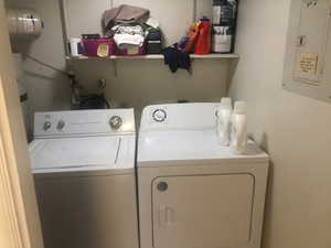 Laundry area featuring electric panel and washer and dryer