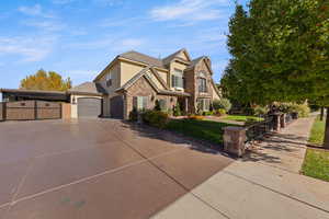 View of front of property featuring stucco siding, driveway, a fenced front yard, a gate, and an attached garage