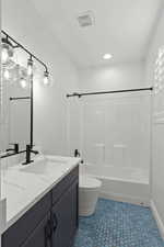 Full bath with vanity, tub / shower combination, dark tile patterned flooring, and recessed lighting