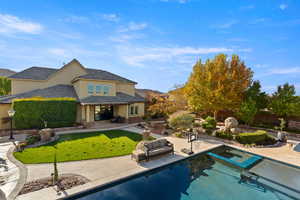 Back of property featuring a patio, stucco siding, a pool with connected hot tub, and a mountain view