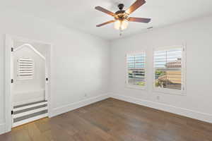 Spare room featuring dark wood-style floors and a ceiling fan