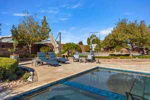 Outdoor pool featuring a patio area and a fenced backyard