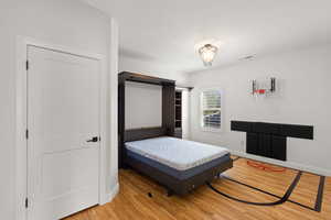 Bedroom featuring light wood-type flooring and a textured ceiling