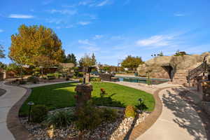 View of home's community with a pool, a yard, a patio, and stairway