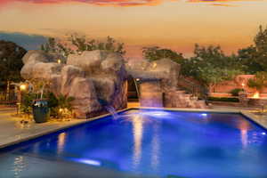 Pool at dusk with an outdoor pool and a patio