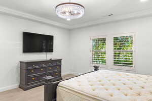Bedroom featuring light colored carpet, crown molding, a chandelier, and recessed lighting