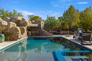 View of pool featuring a pool with connected hot tub, a patio area, and stairway