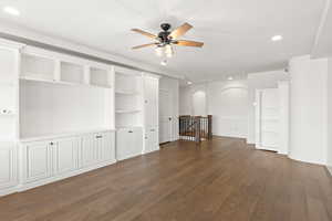 Unfurnished living room featuring recessed lighting, dark wood-type flooring, ceiling fan, and built in shelves