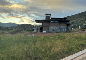 View of home's exterior with a mountain view, a chimney, and stone siding