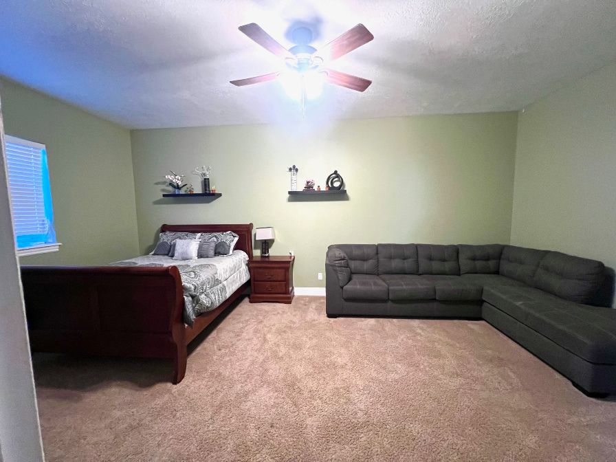 Huge bedroom/guest suite with walk in closet, ceiling fan and new carpet.